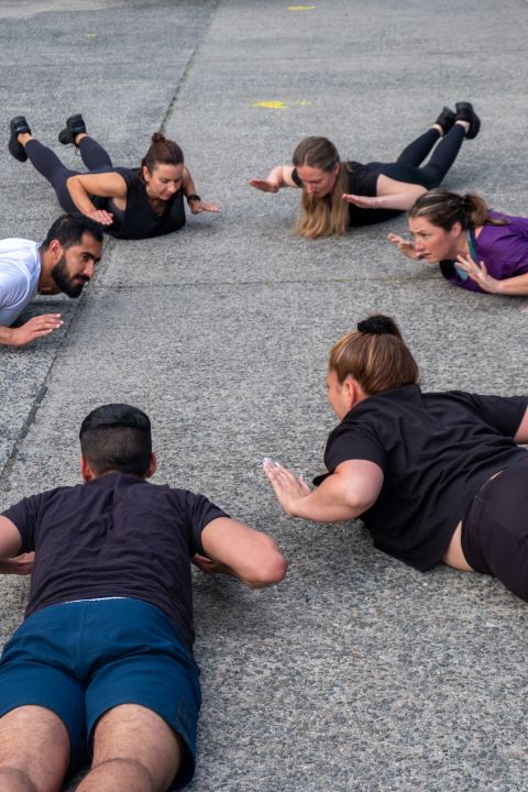 Fitness Fort 6 Personen machen Fitnessübungen auf dem Boden