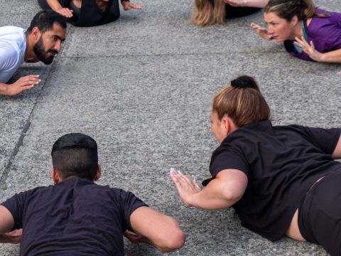 6 Personen machen Fitnessübungen auf dem Boden