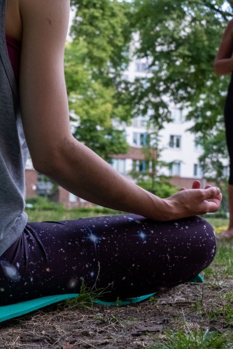 Yoga & Meditation im Sitzen meditierende Person im Park